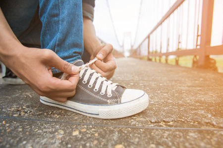Men in jeans  tie his  shoesの写真素材