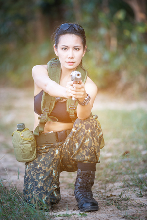 Beautiful woman soldier with a pistolの写真素材