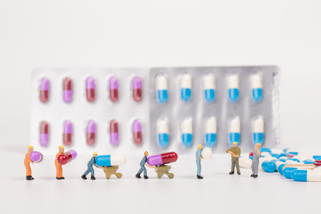 medical drug capsule and miniature people on white background,medical concept