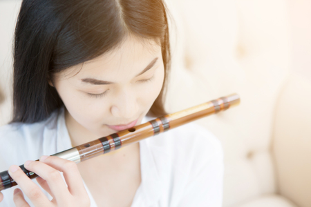 asian girl playing bamboo fluteの写真素材