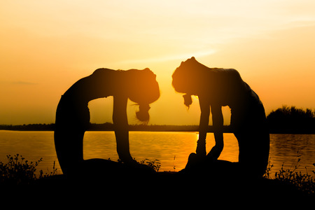 Silhouette Asia woman yoga on sunset. Sunset sky backgroundの写真素材