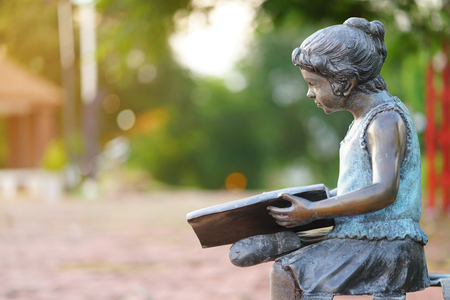 statue woman reading book in the gardenの写真素材