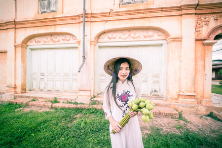 beautiful woman with Vietnam culture tranditional dress, Ao dai and  holding lotusの写真素材