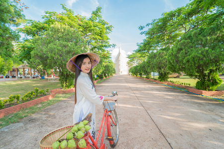 beautiful woman with Vietnam culture tranditional dress, Ao dai and riding bicycleの写真素材