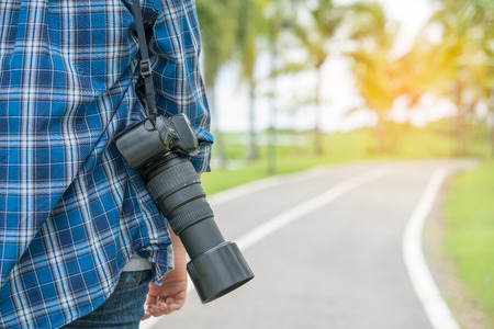 photographer holding camera with nature backgroundの写真素材
