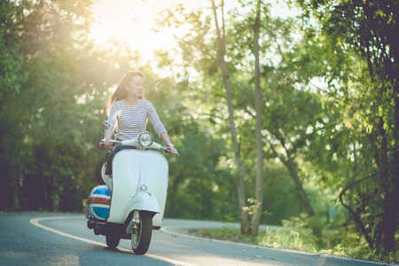tourist and Vespa scooter on roadwayの写真素材