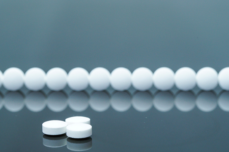 white medical tablet on black background and reflectionの写真素材