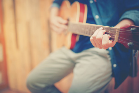 close up hand man playing acoustic guitar in vintage styleの写真素材