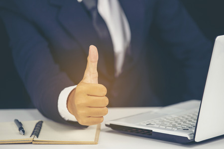 close up businessman showing thumbs up while use laptopの写真素材