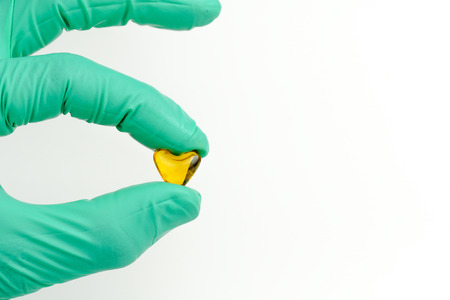 hand holding  cod liver oil heart shape on white background