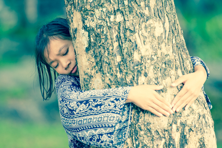 asian girl hugging tree with loveの写真素材