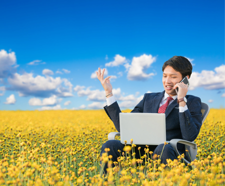 businessman working outdoor in yellow flower fieldの写真素材