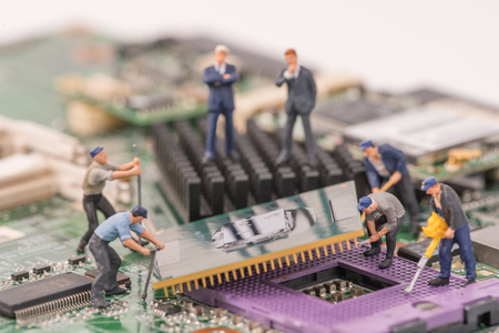 miniature people repair cpu board,teamwork and technology concept