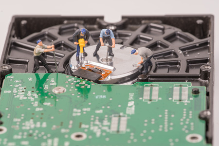 technicial team miniature people repairing  hard drive. Figures of people. The team of employeesの写真素材