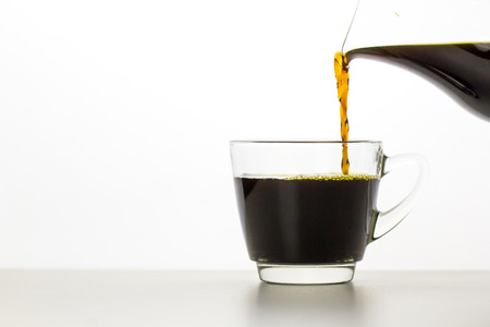 Pouring Coffee into a cup on white backgroundの写真素材