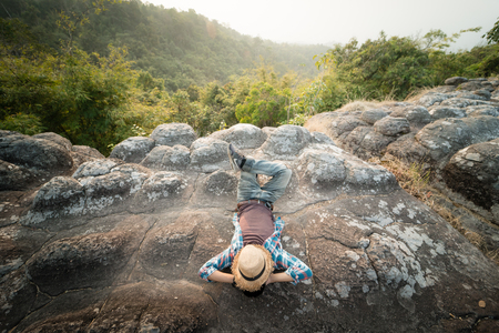 man relax on the rock beside cliff on the Moutainの写真素材
