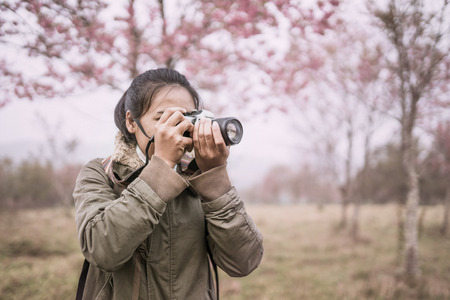 woman photographer shooting in the forest with nature beautiful backgroundの写真素材