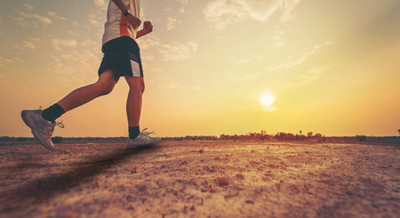 Athlete running with sunrise or sunset backgroundの写真素材