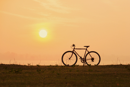 silhouette bicycle with sunset or sunrise backgroundの写真素材