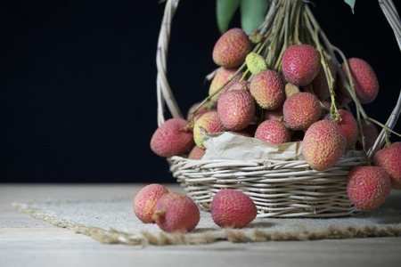 litchi, lichee, lychee, or lichi, Litchi in basket on black backgroundの写真素材