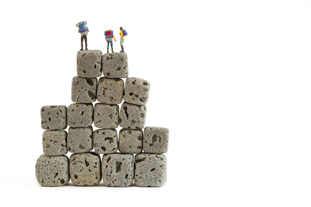 miniature people with cube rock on whote backgroundの写真素材