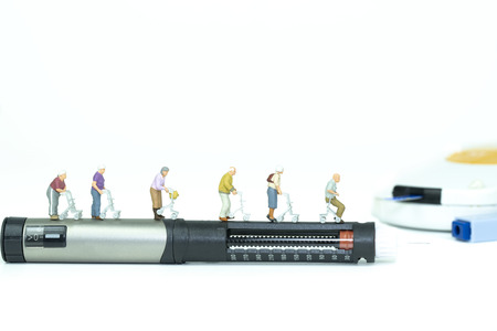 Miniature ederly group walking on insulin pen,medical conceptの写真素材