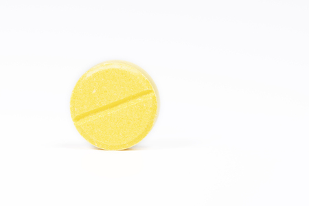 Yellow pill on white backgroundの写真素材