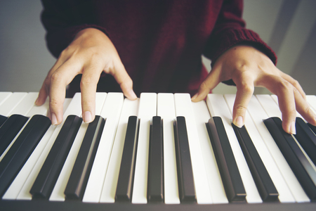 Close up woman hand playing pianoの写真素材