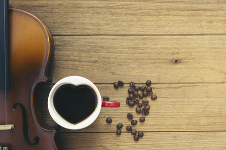 cup ofcoffee and violin on wooden
