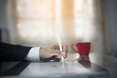 Close up hand using mouse pen drawing on tablet computerの写真素材