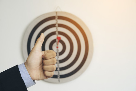 Thumb up with dart board background,business conceptの写真素材
