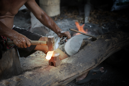 Blacksmith manually forging the molten metal on the anvilの写真素材