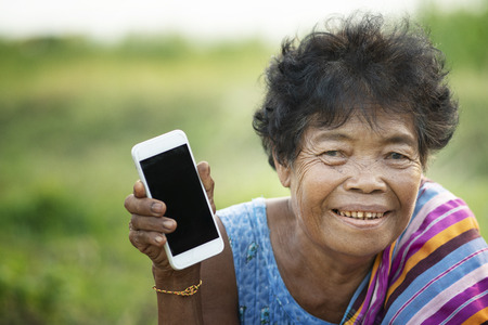 Asian old woman using mobile phoneの写真素材