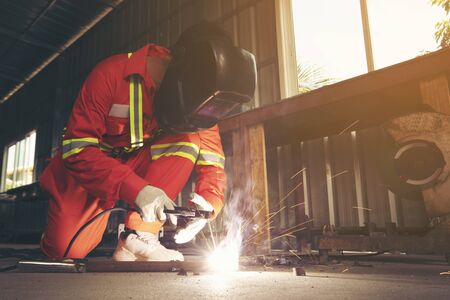 welder with protective uniform welding metal in  shop