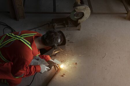 welder with protective uniform welding metal in shop