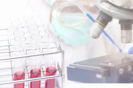 scientist or doctor working research in medical laboratory with microscope and test tube