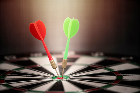 Close up bullseye or dart board has dart arrow hitting the center with black backgrounds, business concepts.の写真素材