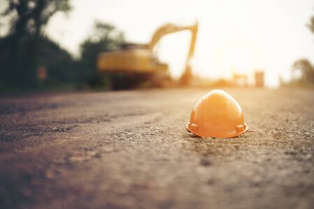 helmet at road construction site and machinery worker background ,safety first conceptの写真素材