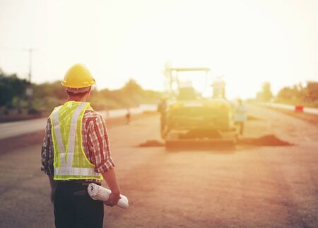 Engineer holding blueprint in construction site