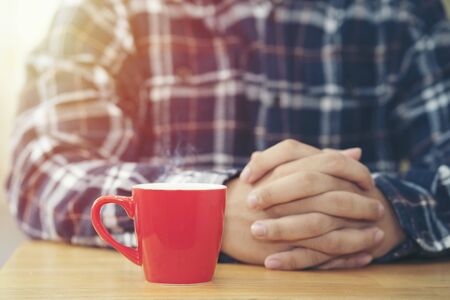 Close up red cup of coffee with manの写真素材