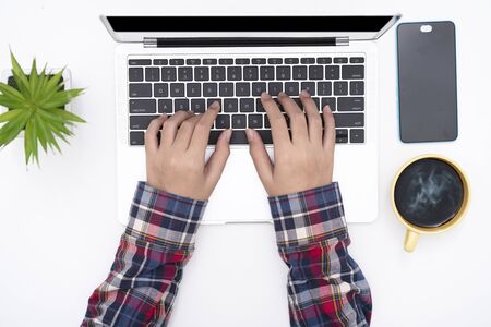 man hands working on keyboard laptop on white table, top viewの写真素材