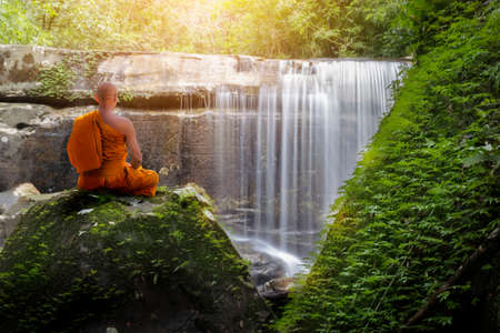 Buddha monk practice meditation with waterfallの写真素材