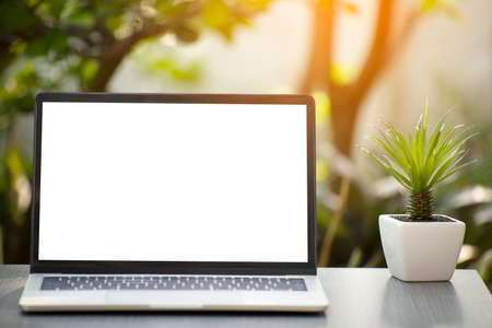 laptop on table with nature in garden background