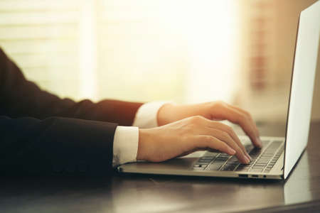 Close-up of businessman's hand typing on  laptop