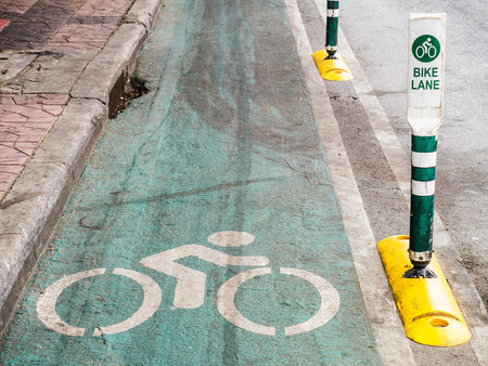 white bicycle road sign painted on green pavement