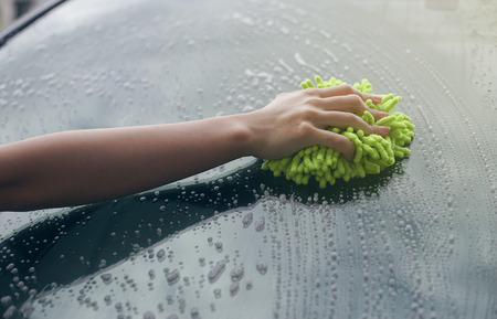 close up woman hand hold a brush washing over the Windshield of the car,woman can wash,woman can doの写真素材