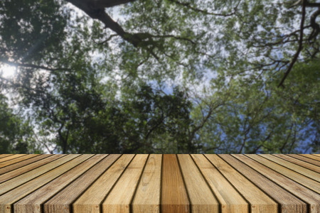 Wooden board empty table in front of natural blurred background. Perspective brown wood over bokeh of tree, can be used for display or present your products.Mock up your productsの写真素材