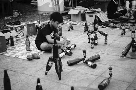 Prachuapkhirikhan,Thailand -October 14, 2016: Unidentified children performs array the bottle at thai traditional market Prachuapkhirikhan Province,Thailand / High contrast black and white picture styleのeditorial素材