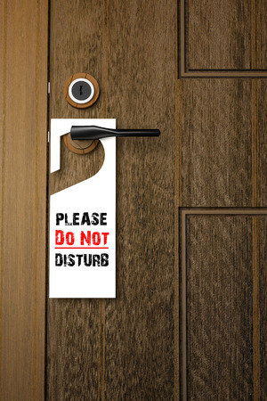 3D : Illustration of white Paper signboard with Please do not disturb text hanging on a handle of wooden door resort or hotelの写真素材