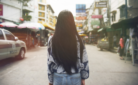 Portrait of Rear view the back of a young long hair asian woman walking at the famous Khao San road in Bangkok. Thailandの写真素材